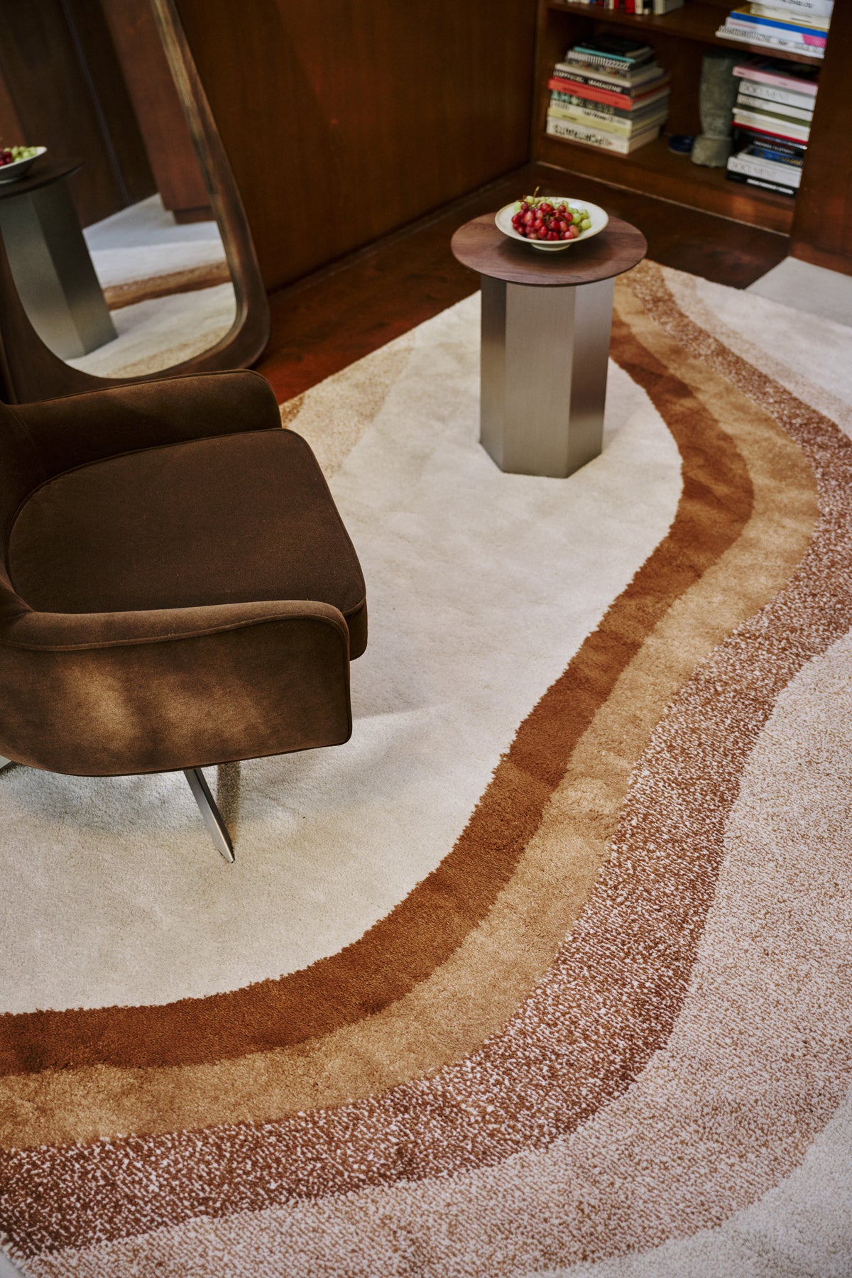 tapis de salon Levante et sa vague caramel sous un fauteuil pivotant en velours brun