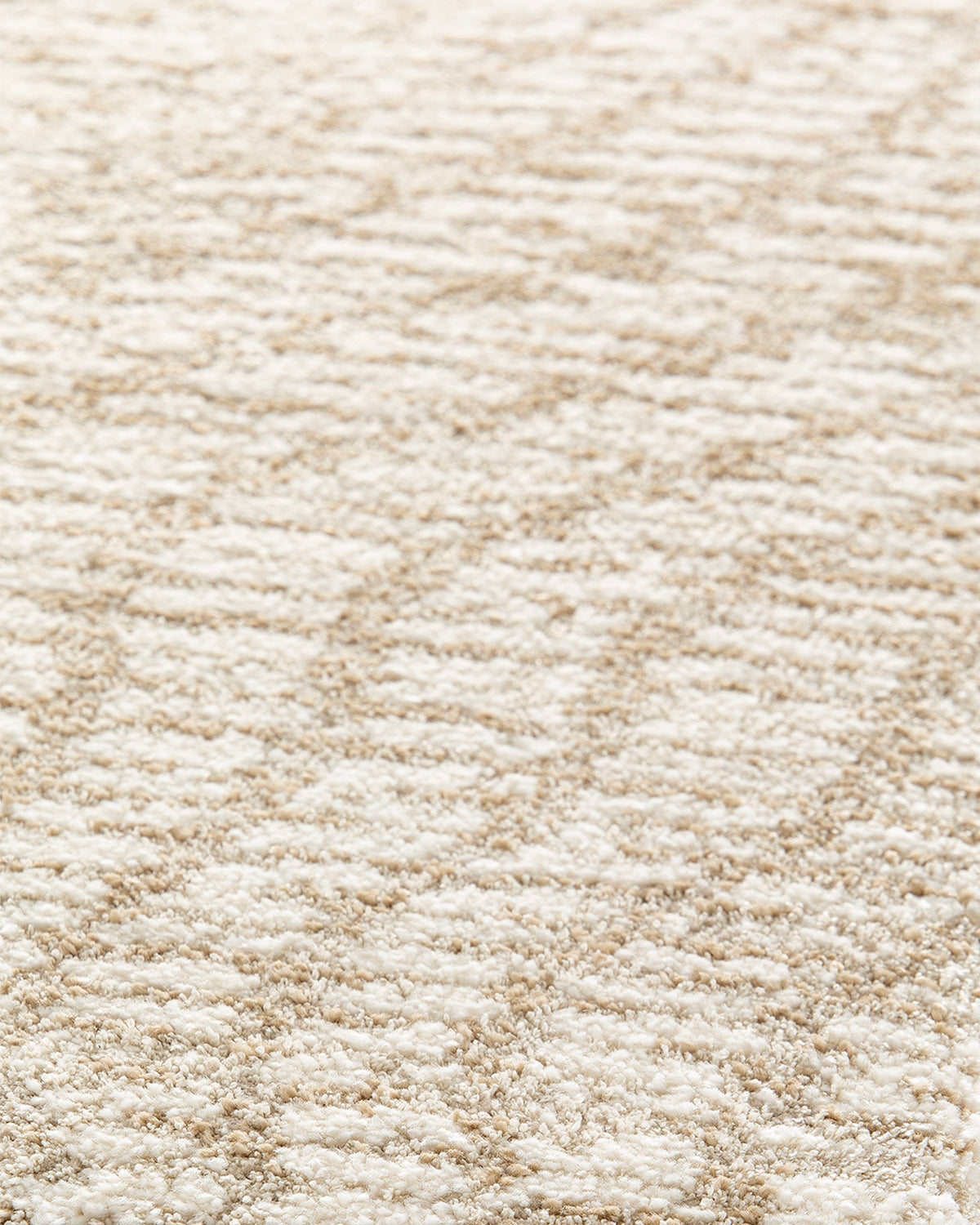 gros plan sur les fines hachures sable qui dessinent les ondulations d'un tapis Cortex