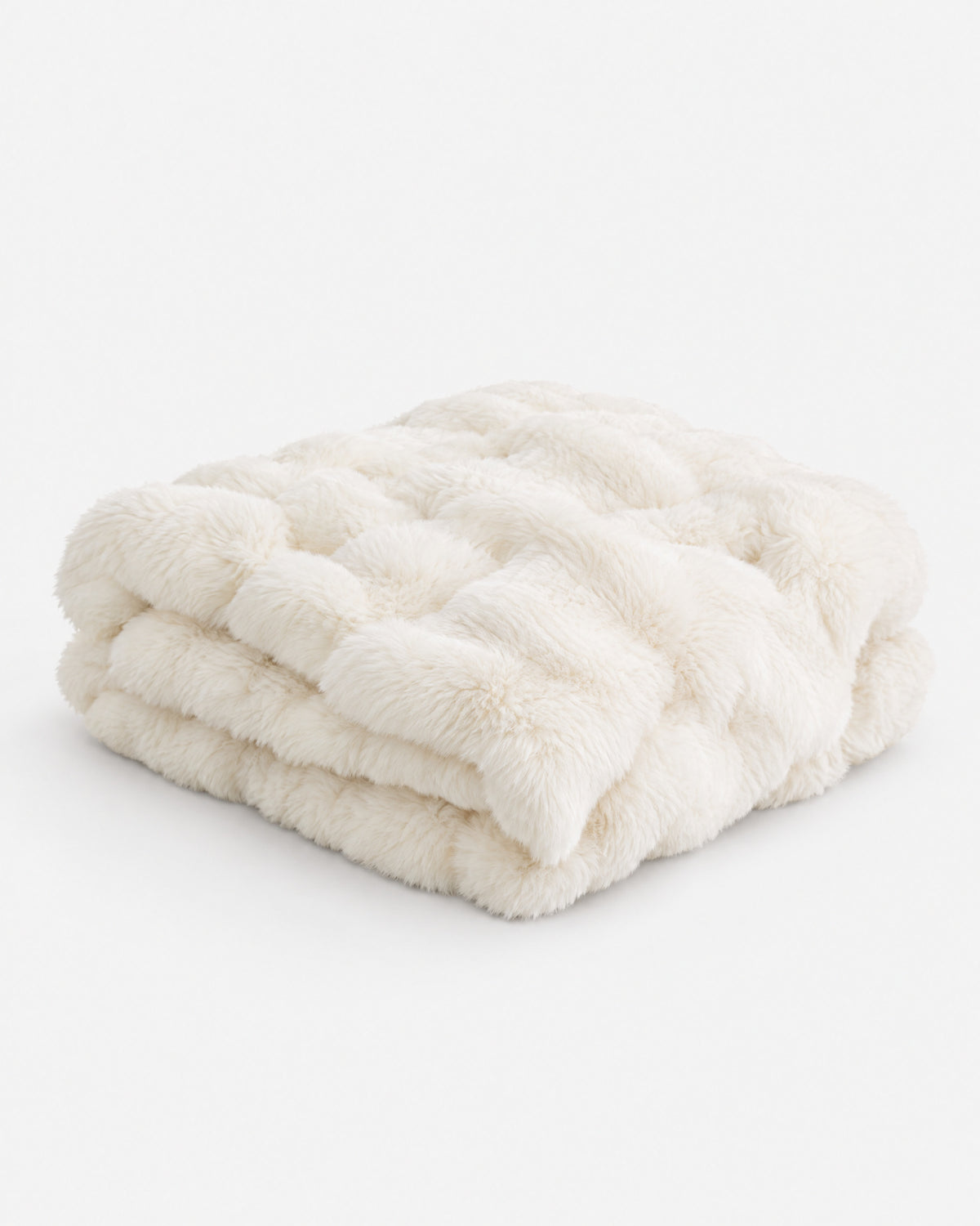 plaid ALPINE en fausse fourrure écrue à larges bandes matelassées, plié et vu de trois quarts