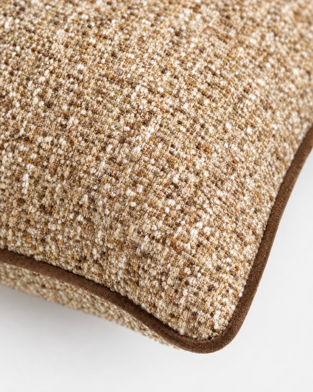 gros plan sur le tweed beige et marron et le passepoil en velours marron du coussin LODGE