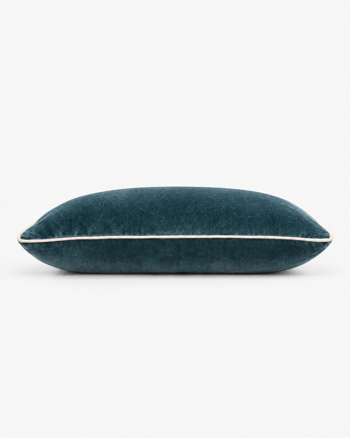 coussin rectangulaire LODGE en velours bleu canard vu de profil, passepoil écru sur la tranche