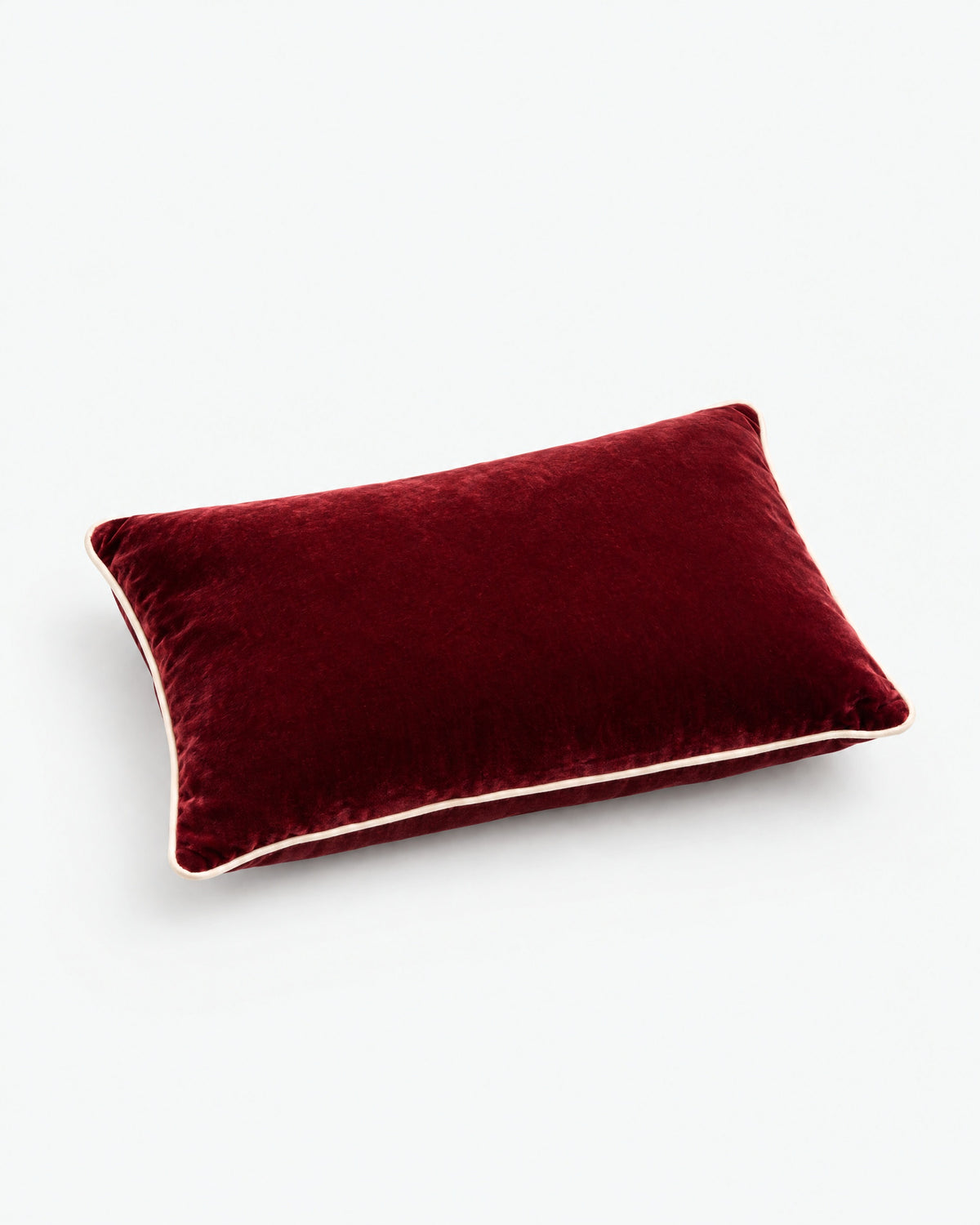 coussin rectangulaire LODGE en velours rouge bordeaux vu de profil, passepoil écru sur la tranche