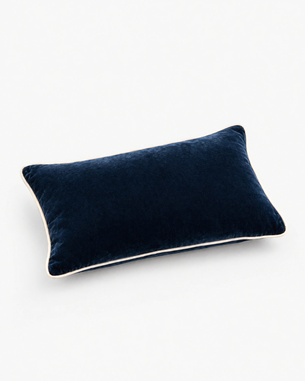 coussin rectangulaire LODGE en velours bleu nuit à passepoil écru, vue de trois quarts